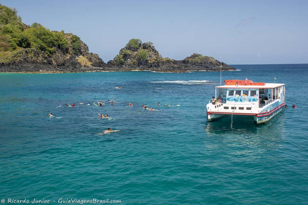 Imagem de turistas nadando em um mar maravilhoso.